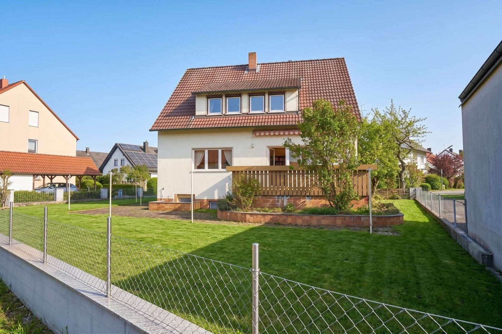 Gepflegtes Wohnhaus mit Garten als Motiv für Immobilienverkauf